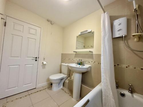 Super Apartment next to Bicester Village Sleeps 4 في بيسستر: حمام مع مرحاض ومغسلة وحوض استحمام