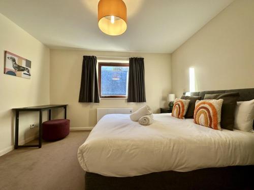 um quarto com uma grande cama branca e uma janela em Super Apartment next to Bicester Village Sleeps 4 em Bicester
