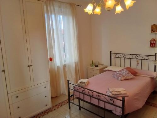 a bedroom with a bed with pink sheets and a dresser at Italy's enchanting ambiance - A snug apartment in Rome in Rome