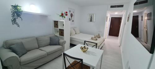 sala de estar con sofá y mesa en Loft Triana Sevilla, en Sevilla
