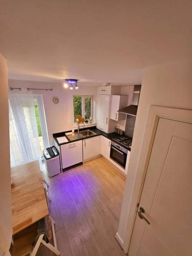 een keuken met witte kasten en een houten vloer bij Stylish 2 Bedroom Semi-Detached House in Leicester in Leicester