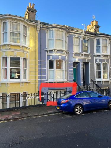 a blue car parked in front of a row of houses at Little Gem in Kemptown Brighton in Brighton & Hove
