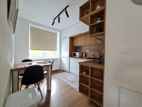 a small kitchen with a desk and a table at Apartman Bazar in Sarajevo