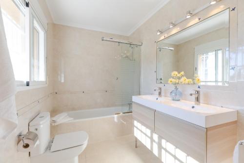 łazienka z umywalką, toaletą i wanną w obiekcie Urban Elegance by Fidalsa w Alicante