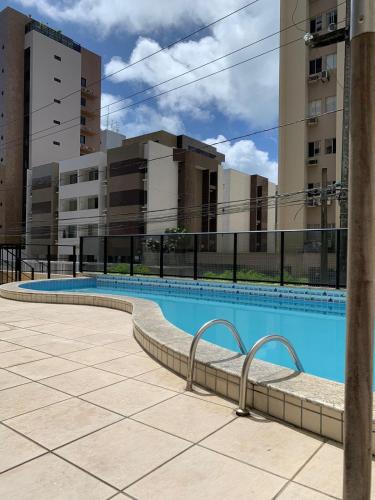 uma piscina vazia com edifícios ao fundo em Apto Q/S a 100m da Praia em Maceió