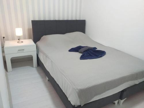 una camera da letto con un letto con una camicia blu sopra di Melisa Apart a Antalya (Adalia)
