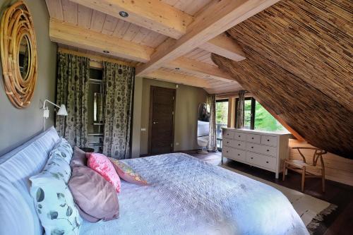 ein Schlafzimmer mit einem Bett in einem Zimmer mit Holzdecken in der Unterkunft SVILPJI Lakeside Retreat House in a Forest with all commodities in Amatciems