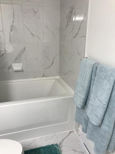 a bathroom with a white tub and a blue towel at Homelike & cozy suite in Langley