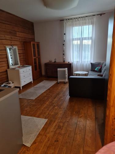 a living room with a couch and wooden floors at Cosy studio near Aqva Spa in Rakvere