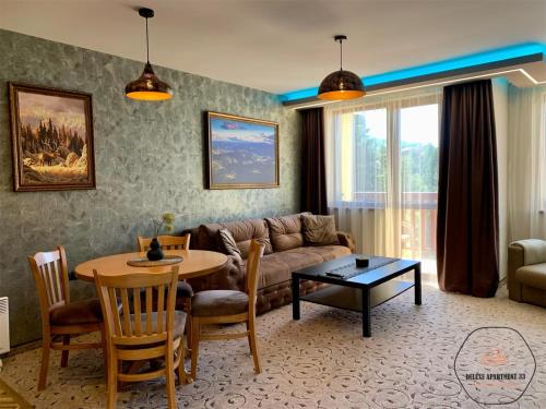 Deluxe Apartment 33 Mountain Lodge Pamporovo في بامبوروفو: غرفة معيشة مع أريكة وطاولة