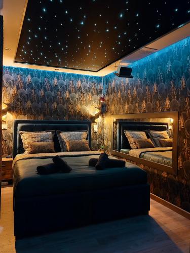 - une chambre avec 2 lits et un mur orné d'étoiles dans l'établissement Le Quai Amiénois - Romance Tropicale - SPA Romantique, à Amiens