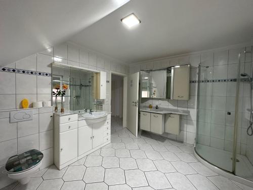 a bathroom with a sink and a toilet and a shower at Ferienwohnung am Hafen Rüstersiel in Wilhelmshaven