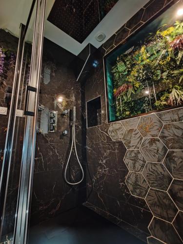 La salle de bains est pourvue d'une douche et d'une peinture murale. dans l'établissement Le Quai Amiénois - Romance Tropicale - SPA Romantique, à Amiens