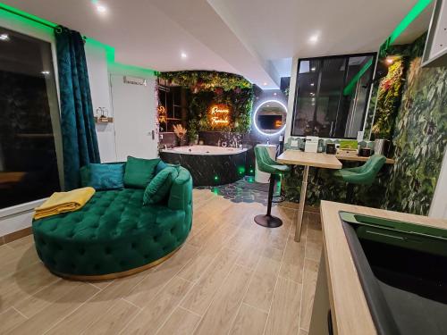 un bagno con divano verde e vasca di Le Quai Amiénois - Romance Tropicale - SPA Romantique ad Amiens