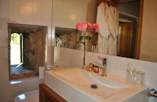 a bathroom with a sink and a vase with flowers at Torres de Moreda in A Estrada