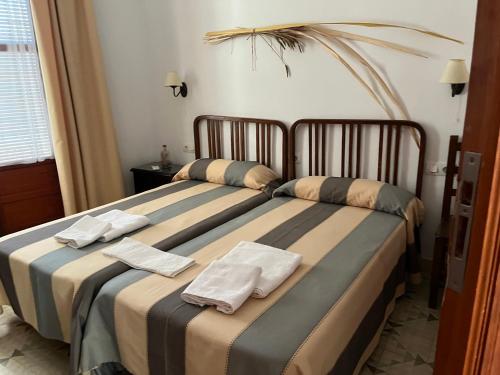 a bedroom with two beds with towels on them at La Casa de Andújar in Cubas