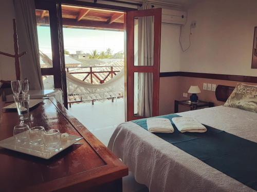 a bedroom with a bed and a table with glasses on it at Garapua Praia Hotel in Garapuá