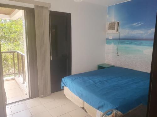 Un dormitorio con una cama con vista al mar. en APARTAMENTO EM CONDOMÍNIO- acolhedor-FRENTE MAR-ENSEADA-TORTUGA, en Guarujá
