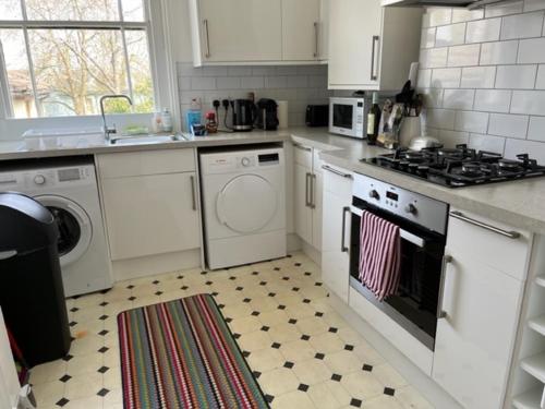 a kitchen with white cabinets and a stove top oven at Tree Tops Apartment in Tunbridge Wells in Royal Tunbridge Wells