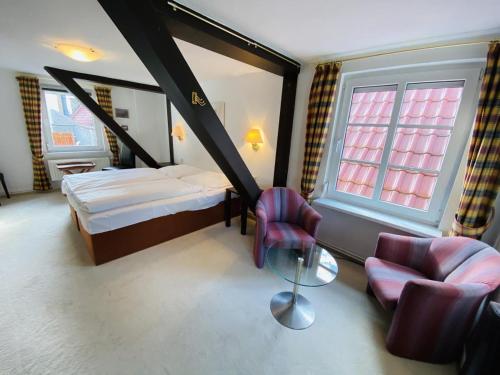 um quarto com uma cama, uma cadeira e uma mesa em Ferienhaus Maria em Warnemünde