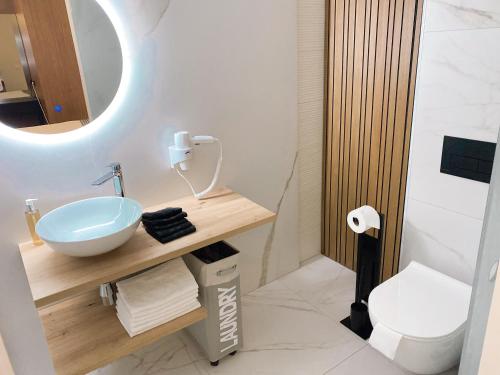 a bathroom with a sink and a mirror and a toilet at ZEŪS apartment in Torremolinos