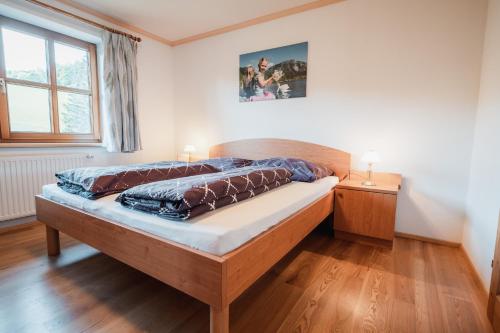 een slaapkamer met een houten bed in een kamer bij Biohof Teufel in Lunz am See