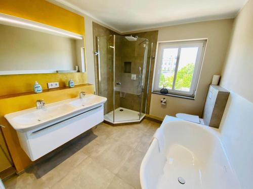 La salle de bains est pourvue de toilettes, d'un lavabo et d'une douche. dans l'établissement Haus Drei Schwestern, Ostseefeeling, am Strand, à Warnemünde