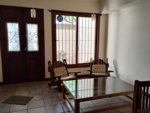 ein Esszimmer mit einem Tisch, Stühlen und Fenstern in der Unterkunft Hostel Terminal in Barraquero