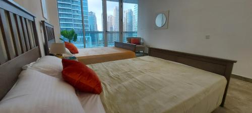 a hotel room with two beds and a large window at Casa Vera Vacations in Dubai