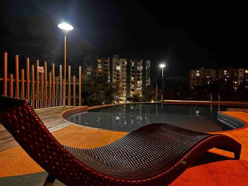 a bench sitting in front of a pool at night at Apartamento nuevo, central, hermosa vista. in Dosquebradas