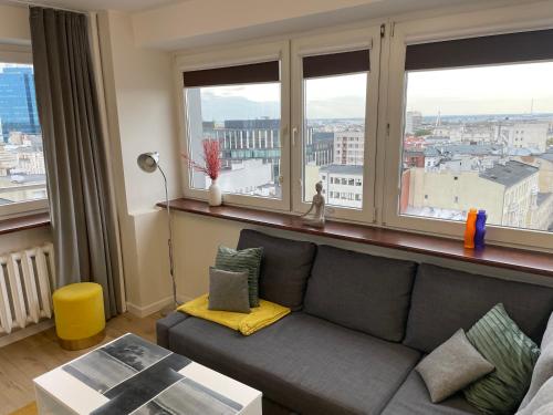 a living room with a couch and a large window at ComeWa Apartments in Warsaw