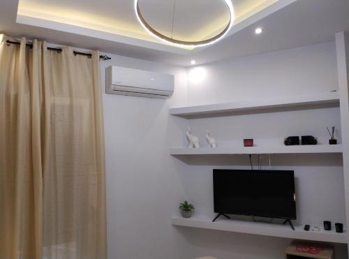 a living room with a television and a curtain at Domus Apartment - City Center in Veria