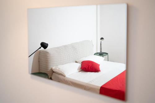 a bedroom with a red pillow on a bed at Pop House - Spacious flat next to Cathedral & Lake in Como