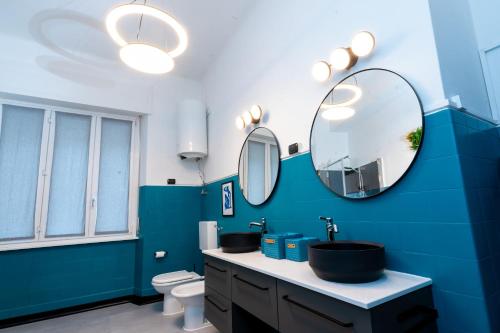 a blue bathroom with a sink and a mirror at Pop House - Spacious flat next to Cathedral & Lake in Como