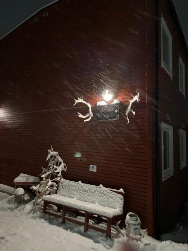 ławka w śniegu przed budynkiem w obiekcie Haugen Pensjonat Svalbard w mieście Longyearbyen