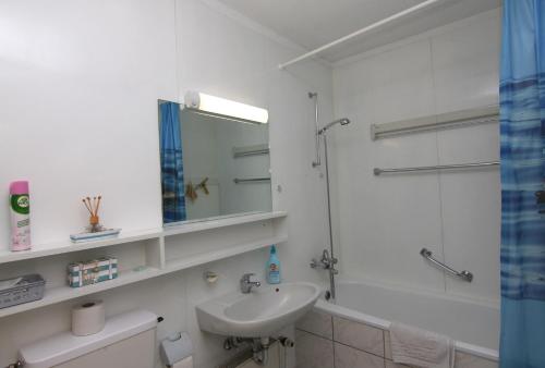 a white bathroom with a sink and a shower at Ferienwohnung L417 für 2-4 Personen an der Ostsee in Schönberg in Holstein