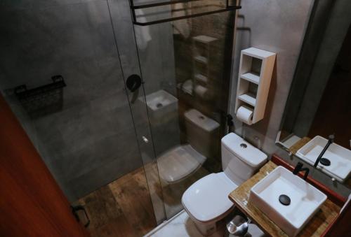 a bathroom with a shower and a toilet and a sink at Pousada Paudoro in Conceição do Mato Dentro