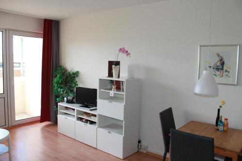 a living room with a table and a white cabinet at Ferienappartement K111 für 2-4 Personen in Strandnähe in Schönberg in Holstein