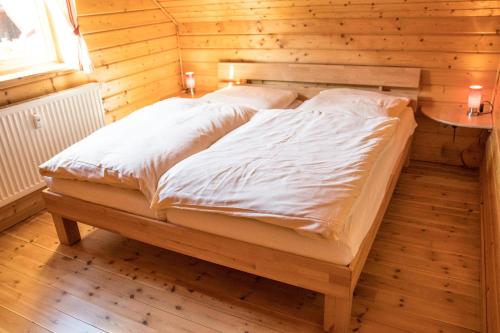 a bedroom with a bed in a wooden room at Ferienhaus 08 Blauvogel in Hasselfelde