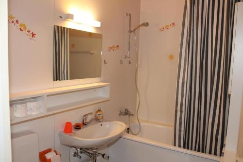 ein Bad mit einem Waschbecken und einer Dusche mit einem Spiegel in der Unterkunft Ferienwohnung L435 für 2-4 Personen an der Ostsee in Schönberg in Holstein