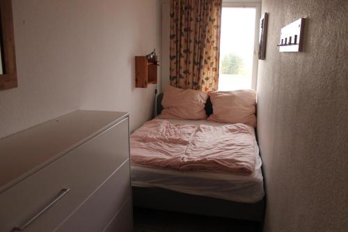 a small bed in a room with a window at Ferienwohnung L412 für 2-4 Personen an der Ostsee in Schönberg in Holstein