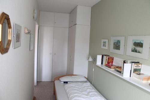 ブラズィリアンにあるFerienwohnung F419 für 2-4 Personen an der Ostseeのベッド1台、本付きの棚が備わる小さな客室です。