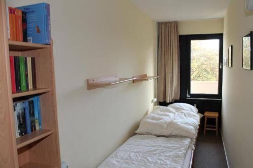 a room with two beds and a book shelf at Ferienwohnung F237 für 2-4 Personen an der Ostsee in Brasilien