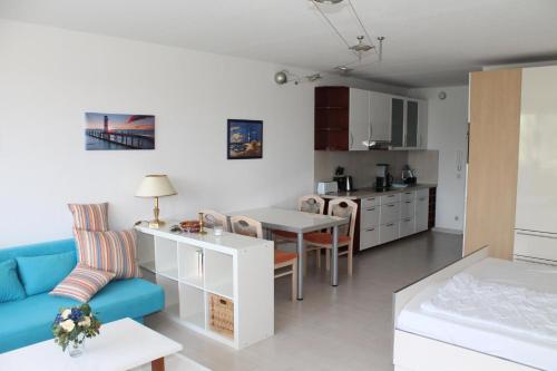 a living room with a blue couch and a kitchen at Ferienappartement S136 für 2-4 Personen an der Ostsee in Brasilien
