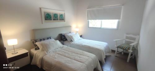 ein kleines Schlafzimmer mit zwei Betten und einem Fenster in der Unterkunft Casa de Montaña María Tequila in Villa Giardino