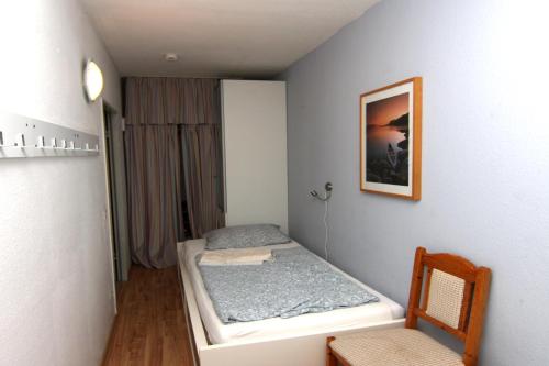 ein kleines Zimmer mit einem Bett und einem Stuhl in der Unterkunft Ferienwohnung F156 für 2-4 Personen an der Ostsee in Brasilien