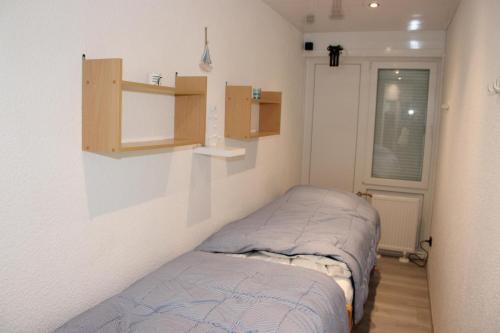 a small bedroom with a bed and shelves on the wall at Ferienwohnung L432 für 2-4 Personen an der Ostsee in Brasilien