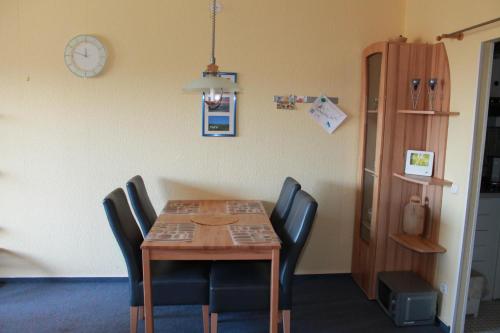 ブラズィリアンにあるFerienwohnung F138 für 2-4 Personen an der Ostseeのダイニングルームテーブル(椅子付)、壁掛け時計