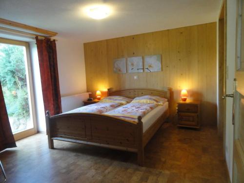 a bedroom with a wooden bed with two lights on it at Landhaus Bonaventura in Millstatt