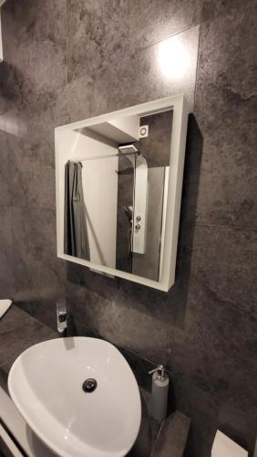 a bathroom with a white sink and a mirror at Apartament pod Dębowcem - Starzyńskiego Valley in Bielsko-Biała